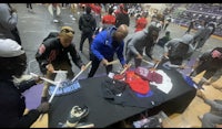 a group of people standing around a table in a gym